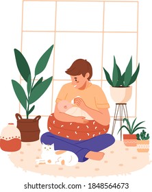 Father feeding her newborn baby in lotus pose with bottle. Man holding infant indoors. Trendy scandinavian hygge interior, living room. Happy fatherhood, baby sitting, father's day concept, banner