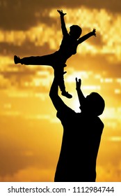 father throws his son up. Silhouettes of father and son.