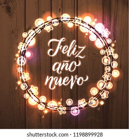 Feliz Ano Nuevo! Spanish Happy New Year. Glowing Christmas White Lights Wreath for Xmas Holiday Greeting Card Design. Wooden Hand Drawn Background.