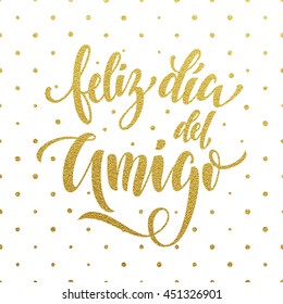 Feliz Dia del Amigo. Friendship Day golden lettering in Spanish for friends greeting card. Hand drawn vector gold calligraphy. Polka dot glitter white background.