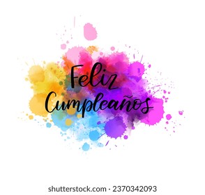 Feliz cumpleaños - Happy birthday in Spanish. Abstract watercolor imitation splash background with calligraphy text.