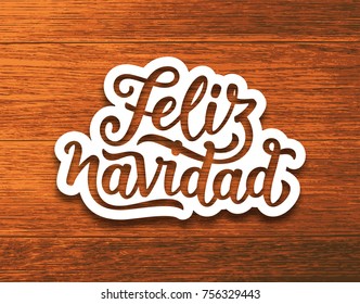 Feliz Navidad spanish Merry Christmas text on white paper cut style label over wood background. Lettering for season greetings. Vector background