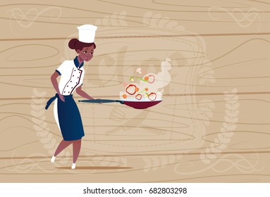 Female African American Chef Cook Holding Frying Pan Cartoon In Restaurant Uniform Over Wooden Textured Background Flat Vector Illustration