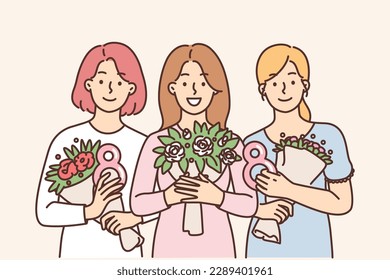 Female with bouquets of flowers presented in honor of International Womens Day and number eight in hands. Happy girls with flowers looking at camera enjoying womens day celebration