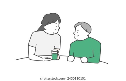 A female caregiver assisting an elderly man with taking medication