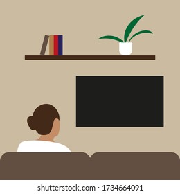 Female character sits on a sofa and looks at the TV screen