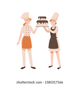 Female confectioners flat vector illustration. Pasty cookers holding two-tier cake with chocolate frosting isolated on white background. Bakers cartoon characters in uniform and chief hats.