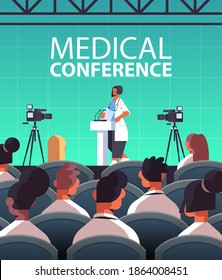 Female Doctor Giving Speech At Tribune With Microphone Medical Conference Medicine Healthcare Concept Lecture Hall Interior Vertical Vector Illustration