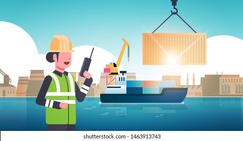 female engineer using walkie-talkie controlling crane hook lifting cargo container box on ship over factory buildings industrial zone sea shipment concept horizontal portrait