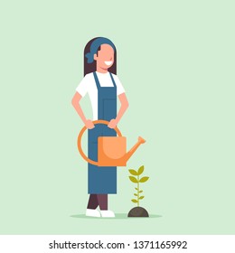 female farmer growing young seedling plant flower or vegetable woman holding watering can gardener in uniform agricultural eco farming concept flat full length
