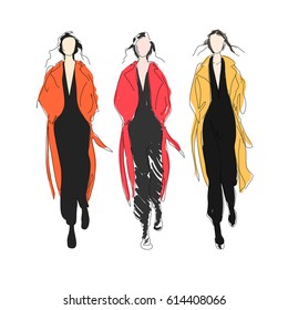 Female fashion models wearing colored coats on runway