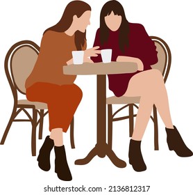 Female friends sit in a cafe at a table and drink juice and talk