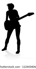 A female guitarist musician in detailed silhouette playing her guitar musical instrument.