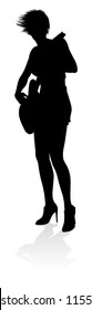A female guitarist musician in detailed silhouette playing her guitar musical instrument.