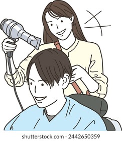 Female hairdresser drying a male customer's hair with a hair dryer