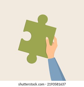 A female hand in a blue sleeve holding an orange puzzle piece on a beige background. Flat vector illustration