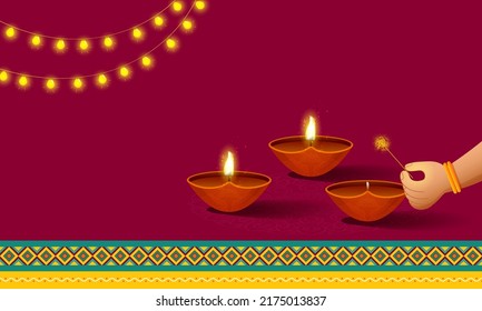 Female Hand Burning Diya From Firecracker Stick And Lighting Garland On Red Background With Copy Space.