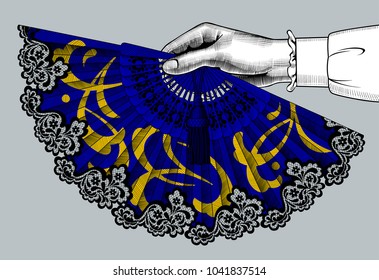 Female hand holding a blue open fan with yellow ornament. Vintage color engraving stylized drawing. Vector illustration