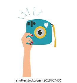 A female hand holding a camera. Vector illustration 