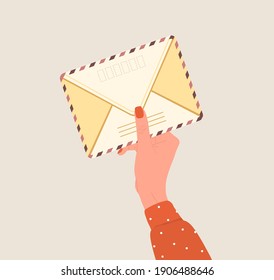 Female hand holding an envelope. Correspondence and mail delivery concept. Top view. Post stamps and postcards. Vector illustration in flat cartoon style. Receiving message, notification, invitation.