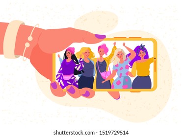 Female hand holding mobile phone with happy smiling men and women  displaying on screen. Friends posing for selfie, group of joyful people photographing themselves, embracing each other, waving hands.