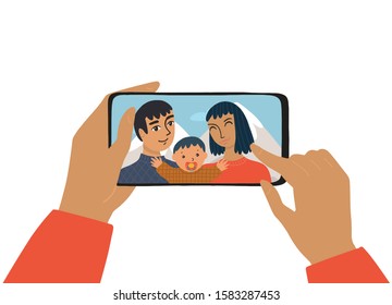 The female hand holds a smartphone. The concept of photography, chat, video call. The family smiles and takes a selfie. The mother and father and son take a photo on vacation.