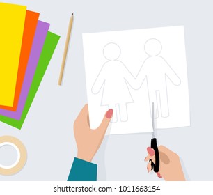 Female hand with scissors cut out silhouette of pair from paper