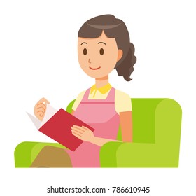 A female home helper wearing an apron sits on a sofa and is reading books