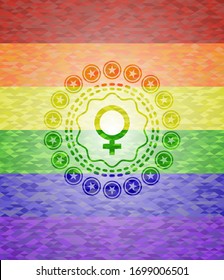 female icon inside emblem on mosaic background with the colors of the LGBT flag