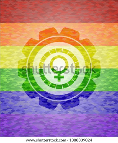 female icon inside emblem on mosaic background with the colors of the LGBT flag