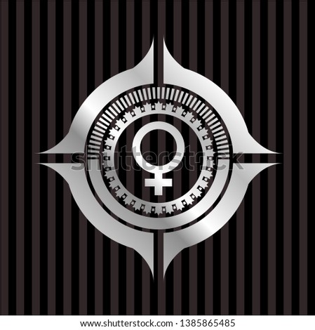 female icon inside silvery emblem or badge