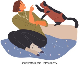 Female pet owner sitting in bed and playing with cat. Caring for animals, joint pastime with pets concept. Happy lady with kitty, domestic animal, human companion. Girl with kitten spends time at home