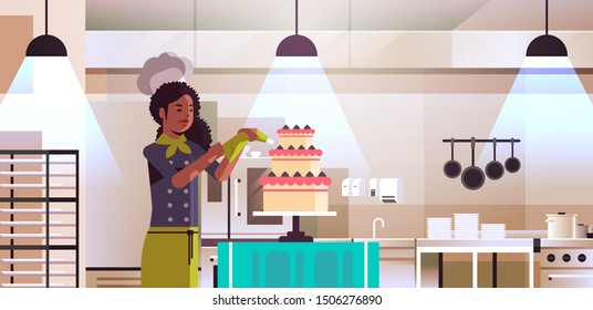 female professional chef pastry cook decorating tasty wedding cream cake african american woman in uniform cooking food concept modern restaurant kitchen interior flat portrait horizontal