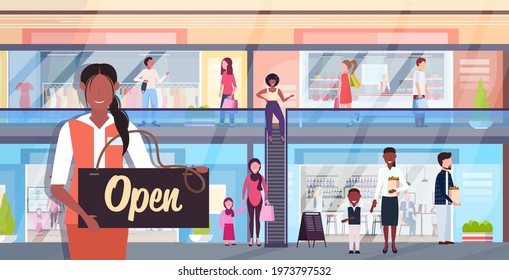 female shop assistant holding open sign board coronavirus quarantine is ending victory over covid-19
