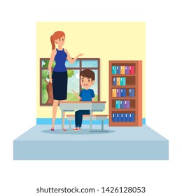 female teacher and boy seated in desk in the classroom
