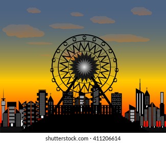Ferris wheel in the evening time against the backdrop of of the city