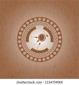 fertilization icon inside badge with wooden background