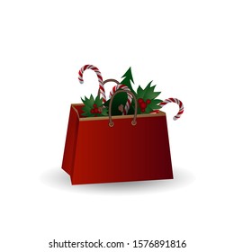 Festive composition with Christmas tree branches and sweets in a gift bag on a white background.