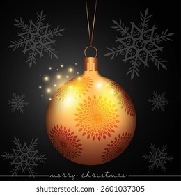 A festive gold Christmas ball with decorative flowers on a black backdrop.