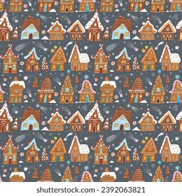 Festive pattern with decorated gingerbread houses, intermingled with Christmas trees, sweets and snowflakes on dark background. Can be used for wallpaper, pattern fills, textile, surface textures