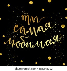 Festive women's day vector card or illustration with glitter gold dots and golden stardust on black background. Hand written lettering "You are loved" in Russian. 