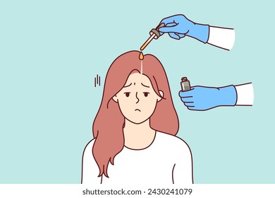 Fighting lice on head of girl sadly attending procedure of applying medicinal ointment for pediculosis to hair. Woman suffering from pediculosis causing itching and hair loss, near hands of doctor