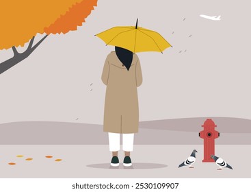 A figure cloaked in a beige coat holds a bright yellow umbrella amidst falling leaves, as gentle rain falls from the sky with pigeons casually exploring nearby, creating a serene autumn atmosphere