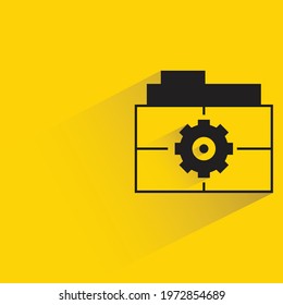 file folder and gear on yellow background
