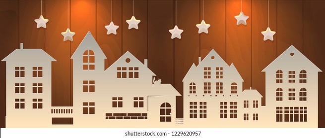 Filigree paper cut silhouette of the street on a wooden background. Christmas street with paper stars in the sky. Paper work illustration