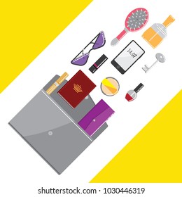 Filling a women's bag. Many items from a women's bag. Hairbrush, cosmetics, wallet.
