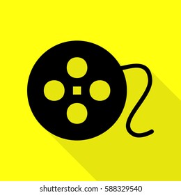 Film circular sign. Black icon with flat style shadow path on yellow background.