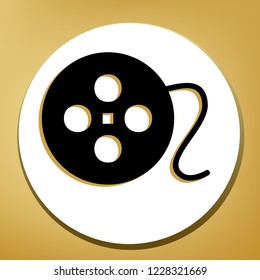 Film circular sign. Vector. Black icon with light brown shadow in white circle with shaped ring at golden background.