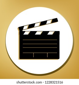 Film clap board cinema sign. Vector. Black icon with light brown shadow in white circle with shaped ring at golden background.