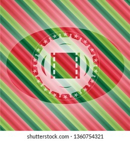 film icon inside christmas emblem.